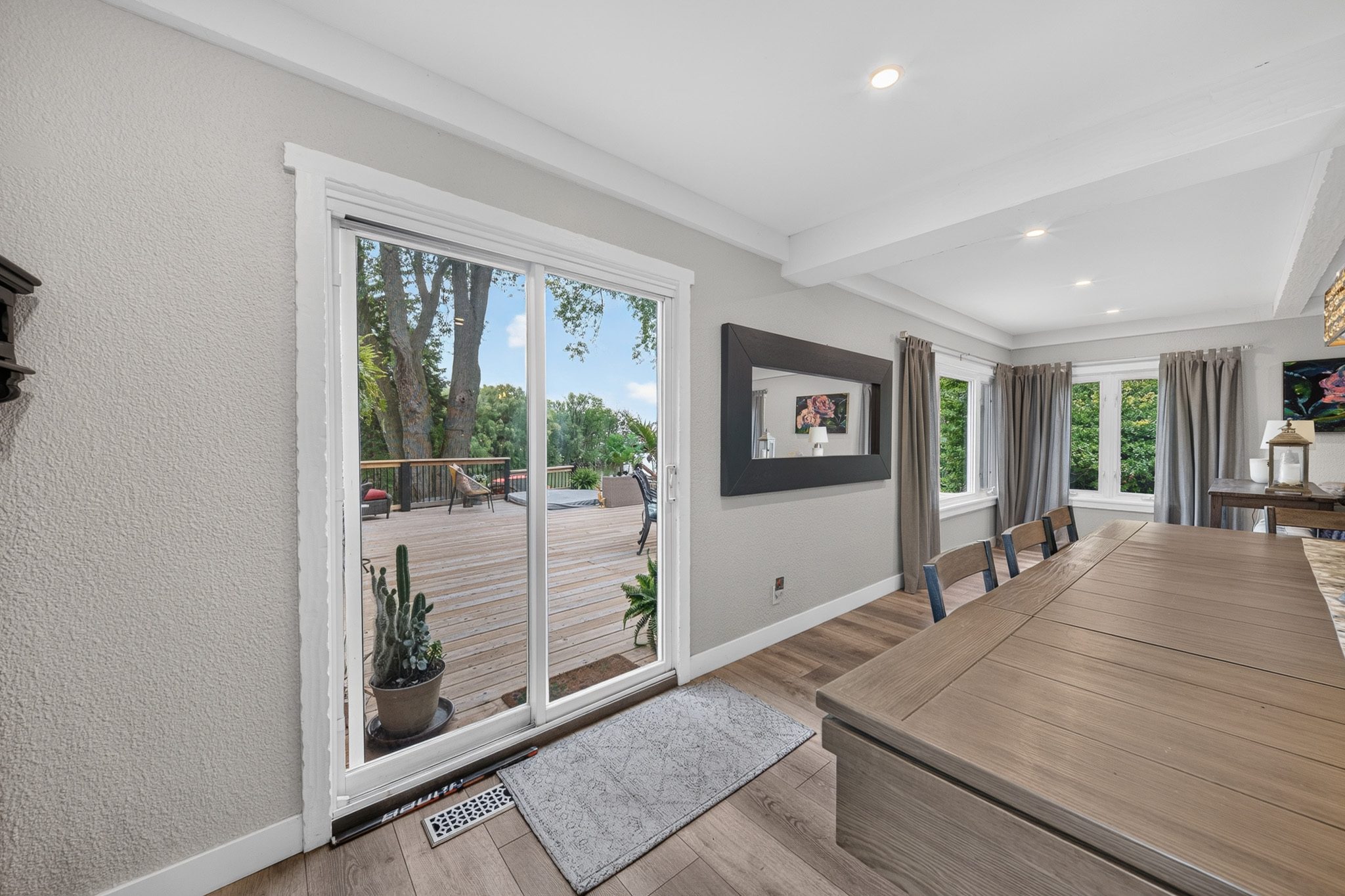 The dining room opening to the deck through glass doors