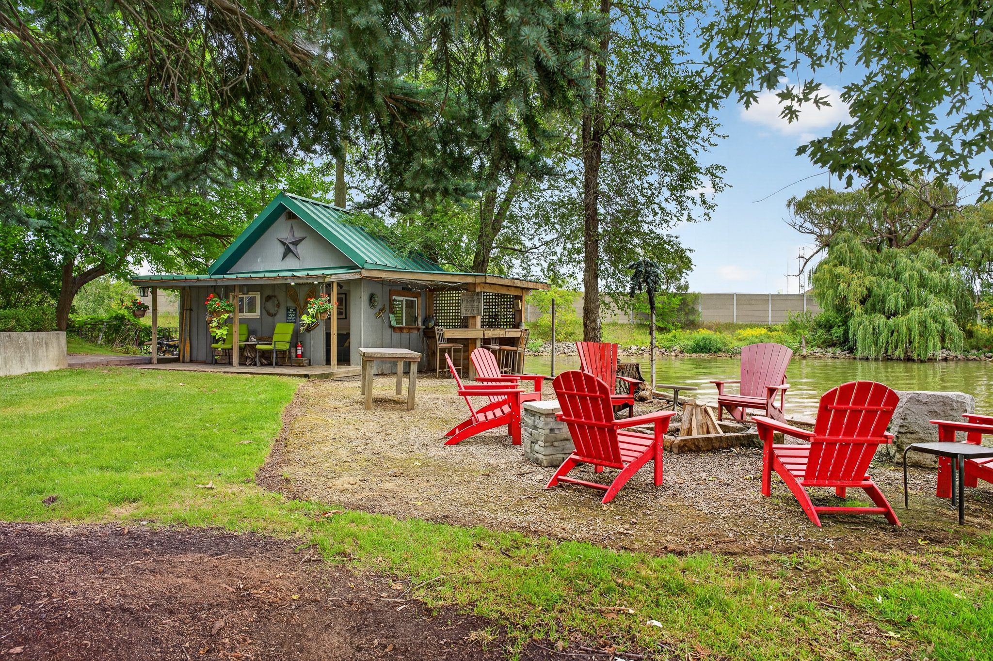 Muskoka chairs around the fire pit by the bunkie