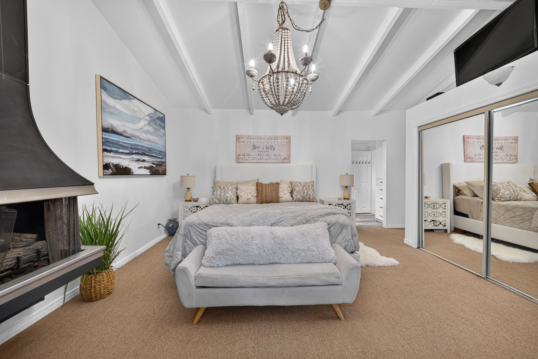 The primary bedroom under the beamed ceiling