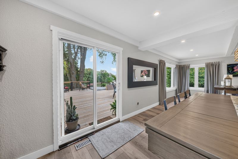 The dining room opening to the deck through glass doors