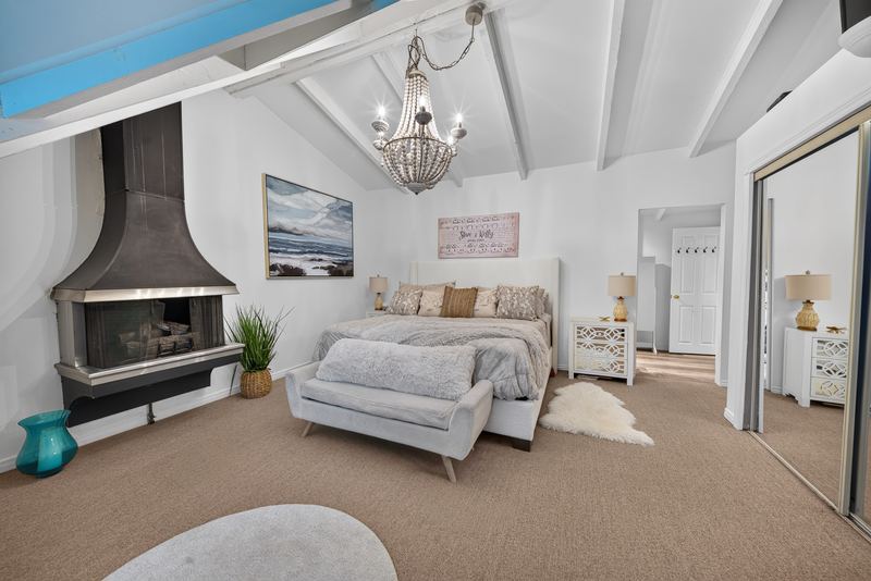 The primary suite with its fireplace and vaulted ceiling